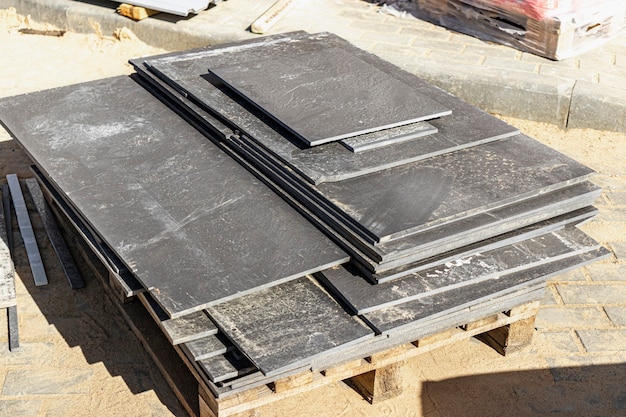 Porcelain stoneware tiles on a pallet at a construction site. Remains of tiles after laying the floor.