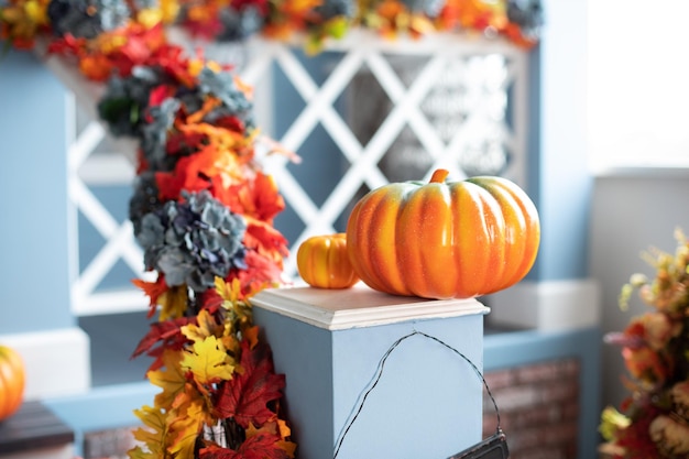 Porch of yard decorated with orange pumpkins in autumn.