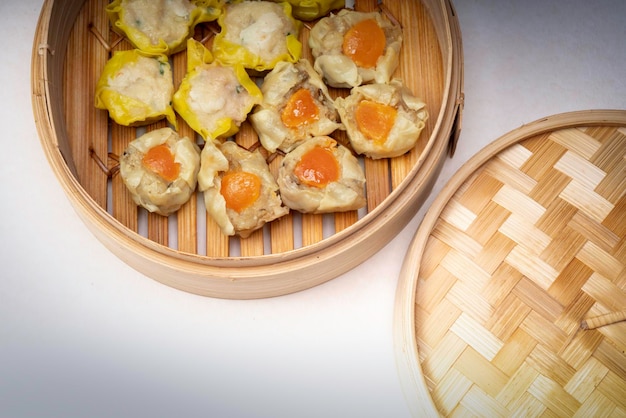 Pork and Crab Dumplings Ready to serve in an oriental woven bamboo basket on a white background