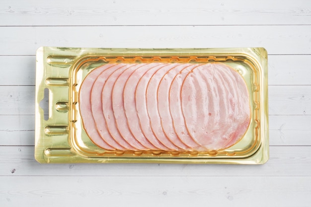 Pork ham in thin slices in a vacuum package on the table Meat sliced carbonate in a package for longterm storage