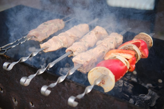 Pork meat and mushrooms on skewer over the charcoal