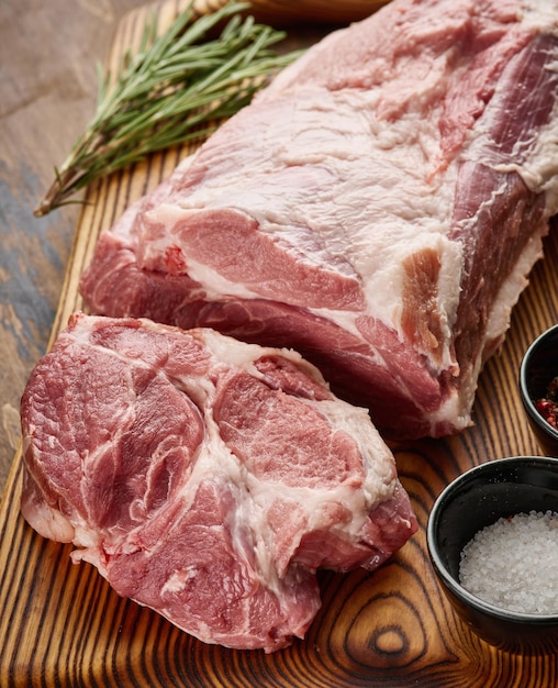 Pork neck meat on a wooden board Fresh raw pork neck with salt and pepper