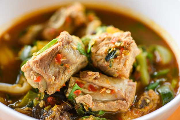 Pork rib curry spicy soup / pork bone with hot and sour soup bowl with vegetables Tom Yum thai herbs Food Asian