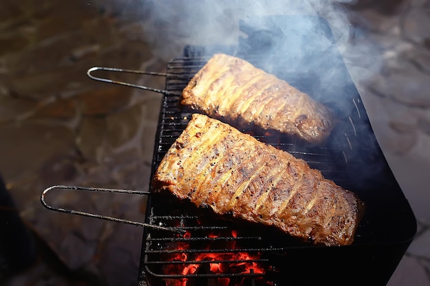 pork ribs on the grill cooking coals / fresh meat pork cooked on charcoal, summer home cooked meal, grilled ribs