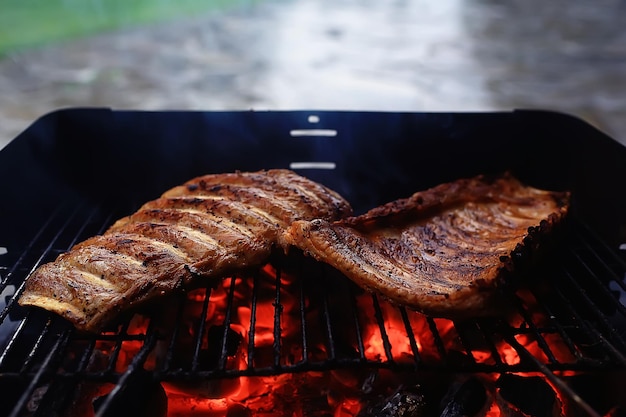 pork ribs on the grill cooking coals / fresh meat pork cooked on charcoal, summer home cooked meal, grilled ribs