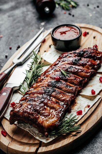 Pork ribs grilled with BBQ sauce Tasty snack on wooden board Food recipe background Close up