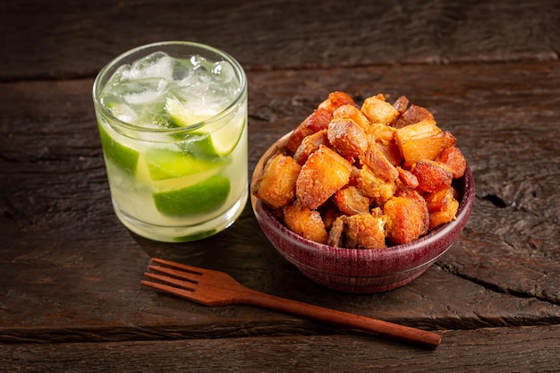 Pork rinds torresmo with caipirinha typical Brazilian food