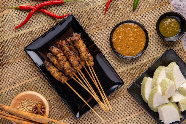 Pork Satay or Sate Babi Pork Satay served with a Peanut sauce and slices of lontong or ketupat rice cakes