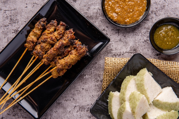 Pork Satay or Sate Babi Pork Satay served with a Peanut sauce and slices of lontong or ketupat rice cakes