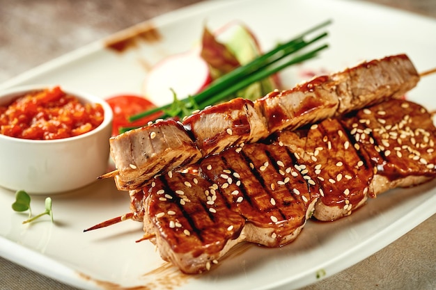 Pork shish kebab with salad and sauce Closeup selective focus Grilled meat