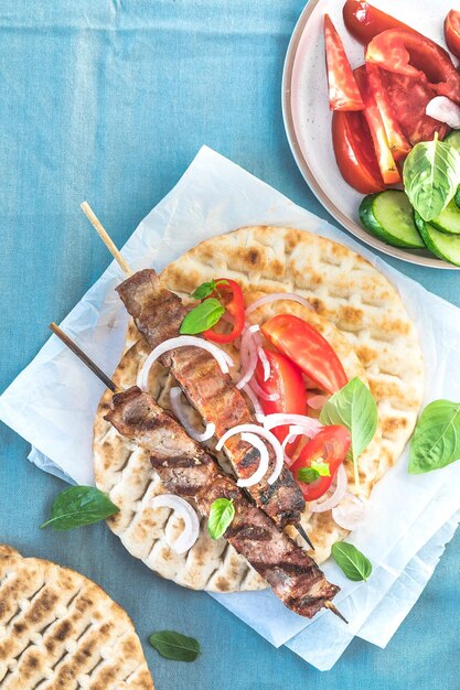 Pork souvlaki kebabs on skewers with salad and fresh home made tzatziki