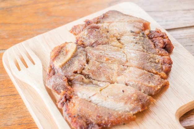 Pork steak on wooden plate