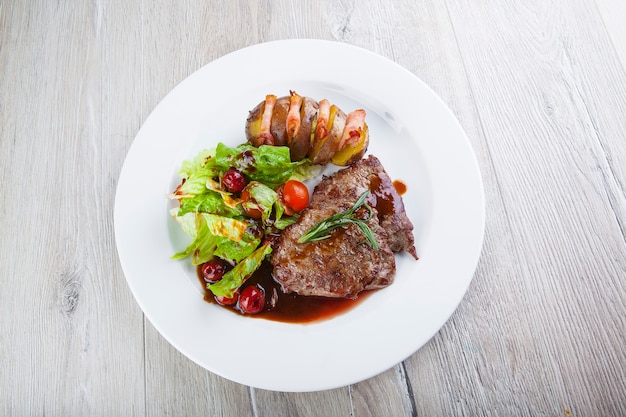 pork stew in sauce with salad and baked potatoes