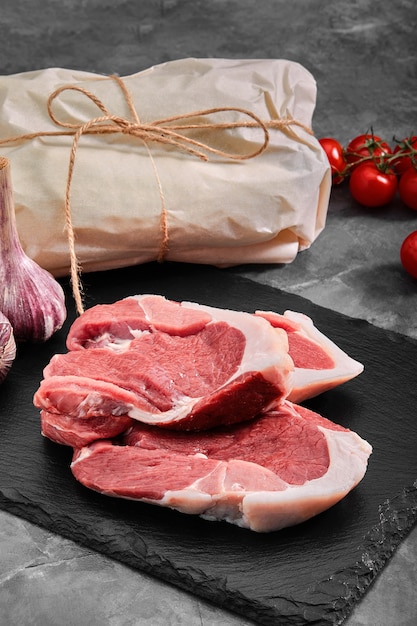 Pork tenderloin meat on a slate plate on a gray background