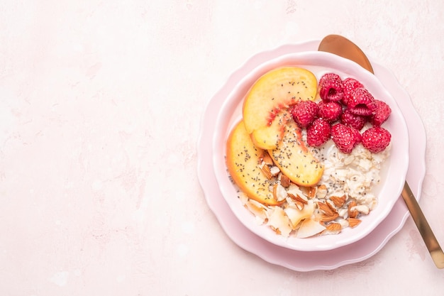 Porridge oatmeal with raspberries peaches and nuts