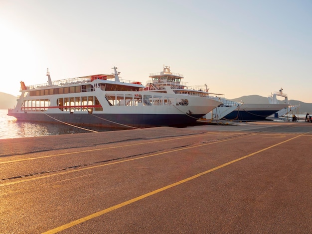 Port with ferryboat at sunset in a spa resort Loutra Edipsou on Greek island of Evia in Greece