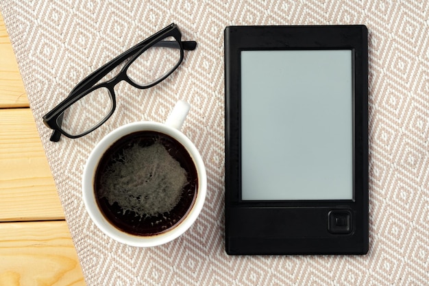 Photo portable ebook reader on wooden background top view