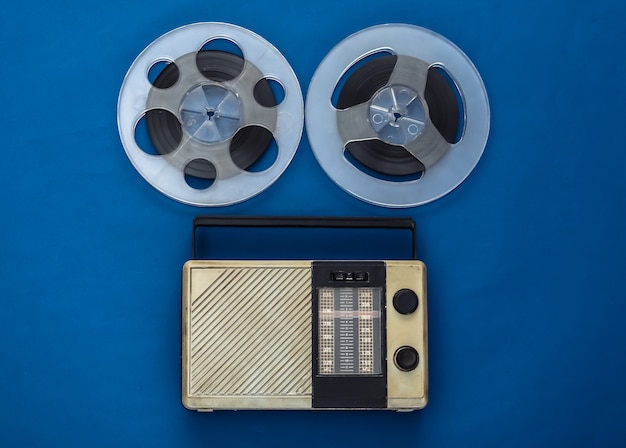 Portable radio receiver and audio magnetic tape reel on classic blue