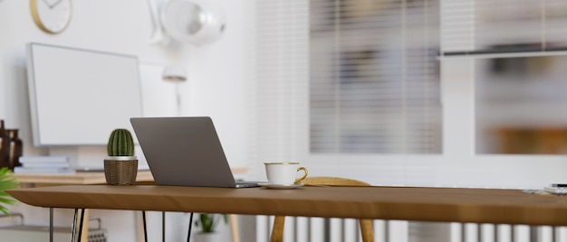 portable workspace with laptop cup and cactus pot on wooden table in office room 3d render