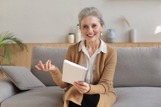 Portait of smiling beautiful middle aged woman looking at camera, making video call, job interview or online dating.