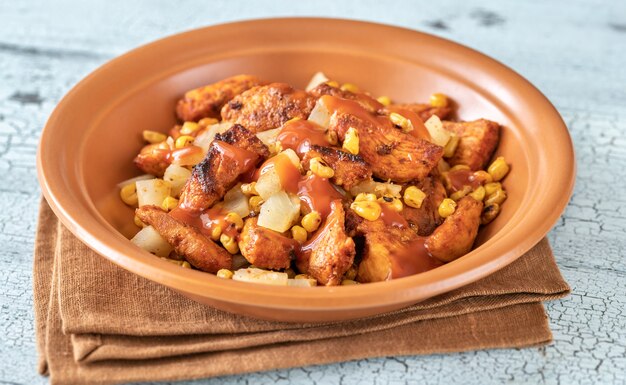 Portion of chicken pineapple salad with grilled corn