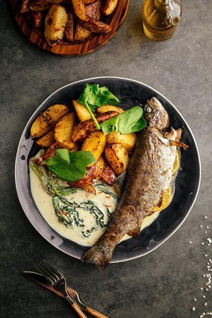 Photo portion of grilled fish with potato and sauce