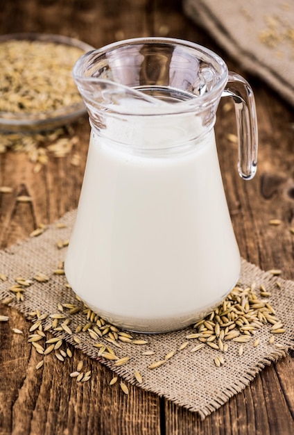 Portion of healthy Oat Milk on an old wooden table selective focus closeup shot