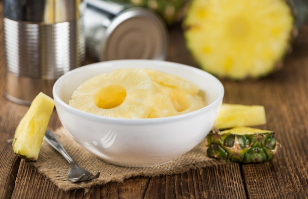 Portion of Preserved Pineapple Rings on wooden background selective focus