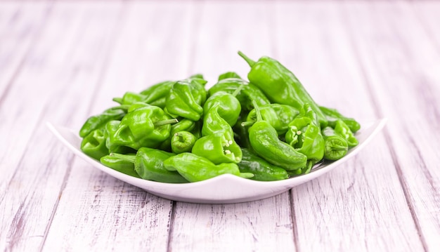 Portion of Raw Pimientos on wooden background selective focus