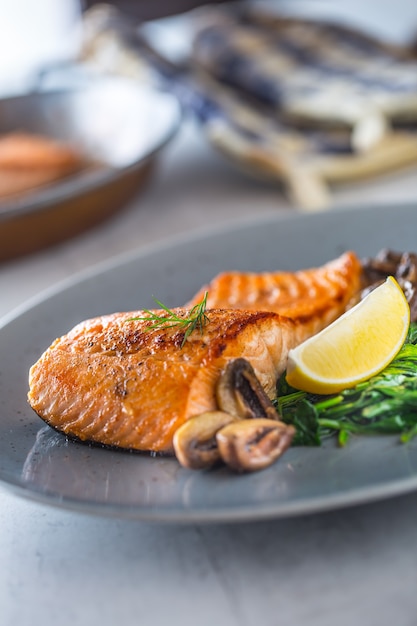 Portion of roast salmon fillet with spinach mushrooms in restaurant pub home or hotel