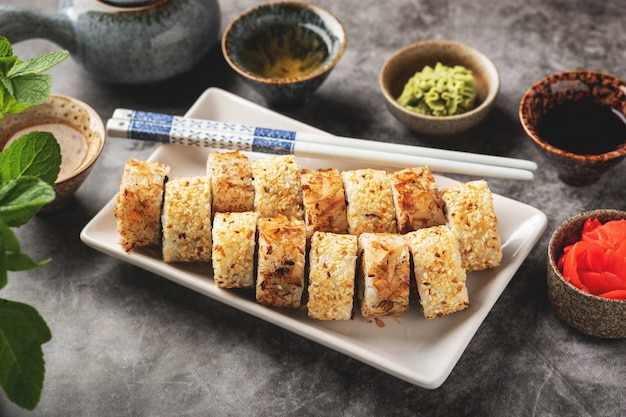 A portion sushi rolls on a plate on the table, close-up