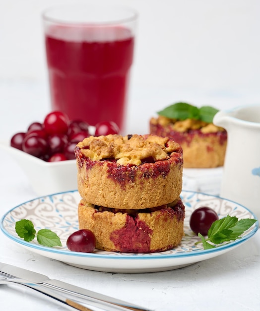 Portioned cherry crumble pie on a plate white background