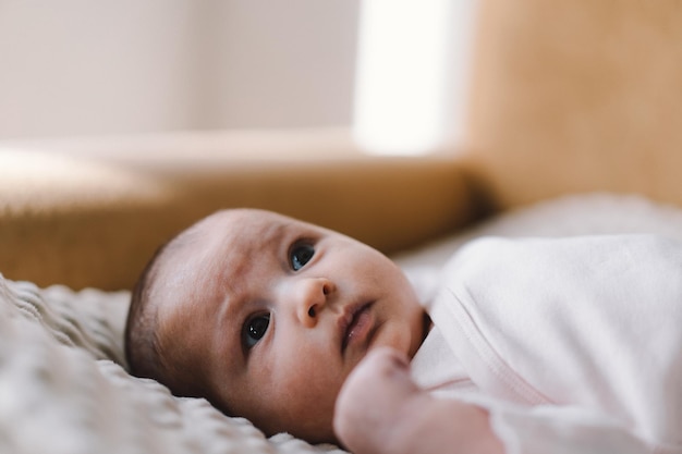 Portrait of a 1 month old baby Cute newborn baby lying on a developing rug Love baby Newborn baby and mother