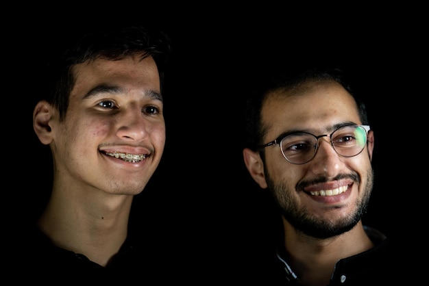 Portrait of 2 young men on a black background. High quality photo