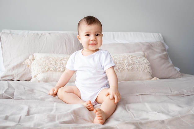 Portrait of a 9monthold girl with brown eyes sitting on a bedxDxA