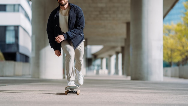 Portrait of active skater boy balancing on skateboard on urban background Focused skateboarder