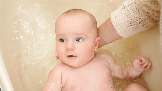 Portrait of adorable baby boy washing in bath