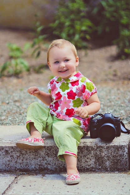 Portrait of adorable cute smiling baby girl sitting near the photo camera