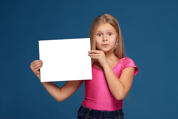 Portrait of adorable emotional little girl on blue background