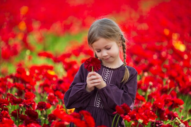 Portrait of adorable girl on a summer meadow. Sunset in the park. Outdoors. Vacations.