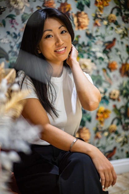 Portrait adorable smiling brunette asian young woman posing at luxury home interior