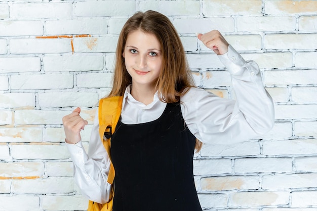 Portrait of adorable student squeeze her fists and looking at the camera High quality photo