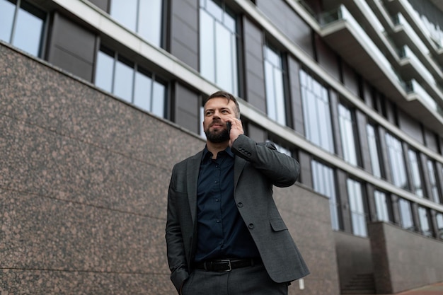 Portrait of an adult male entrepreneur with a mobile phone against the backdrop of an office