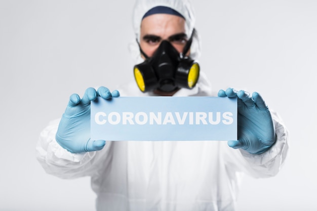 Photo portrait of adult with face mask holding coronavirus sign