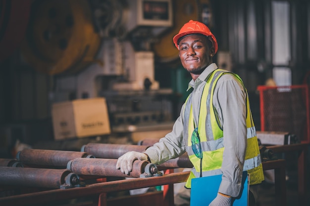 Portrait African American Black afro worker in factory Cameroon Black man employee work in production plant manufacture factory industry and operator line machine steel metal using helmet for safety