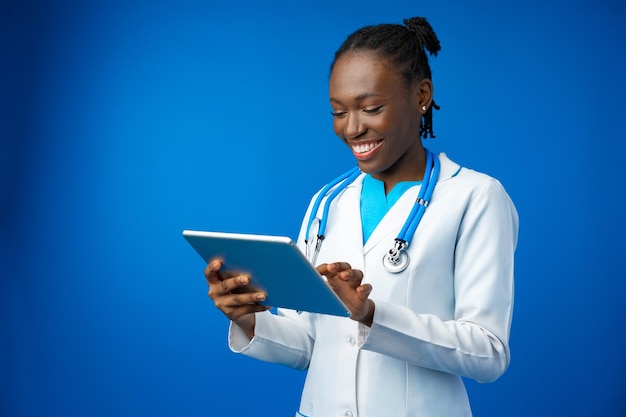 Portrait of an african american female doctor holding a tablet for work in studio