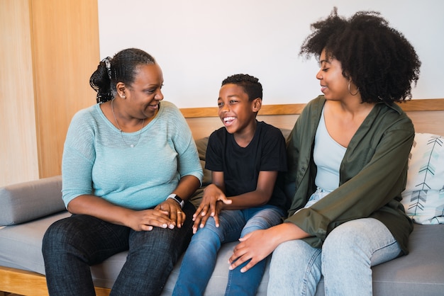 Portrait of African American grandmother, mother and son spending good time together at home