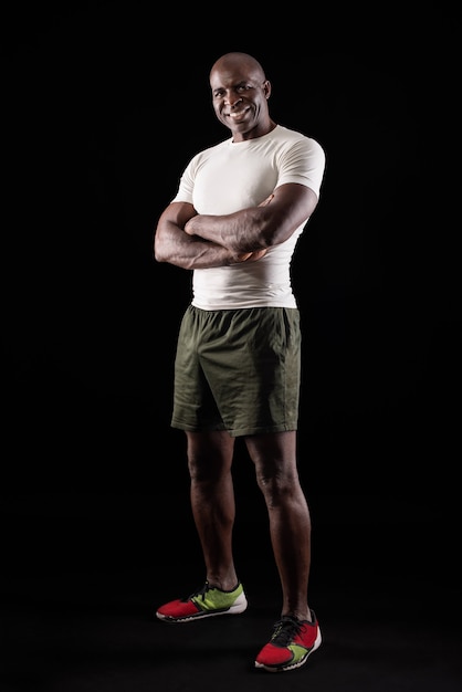 Portrait of african american sportsman posing with crossed arms at studio