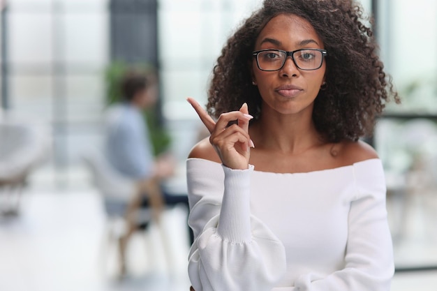 Portrait of african american young business woman showing finger gesture to the side