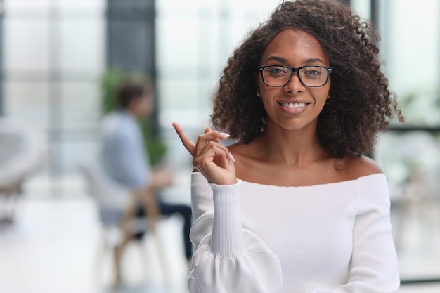 Portrait of african american young business woman showing finger gesture to the side